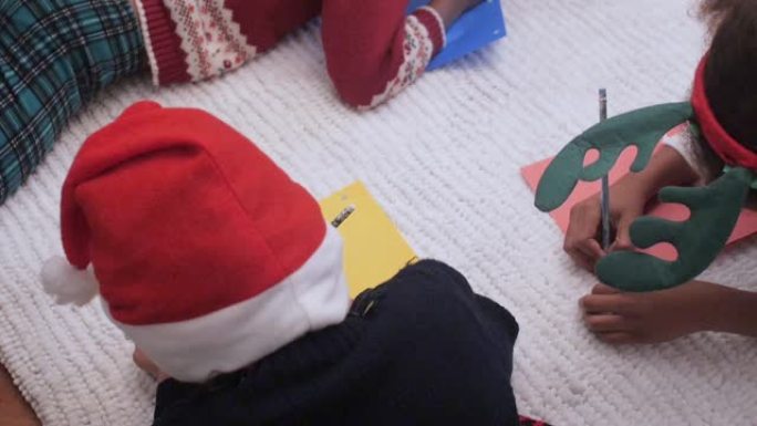 充满爱心的孩子在家里的圣诞树旁写圣诞节信