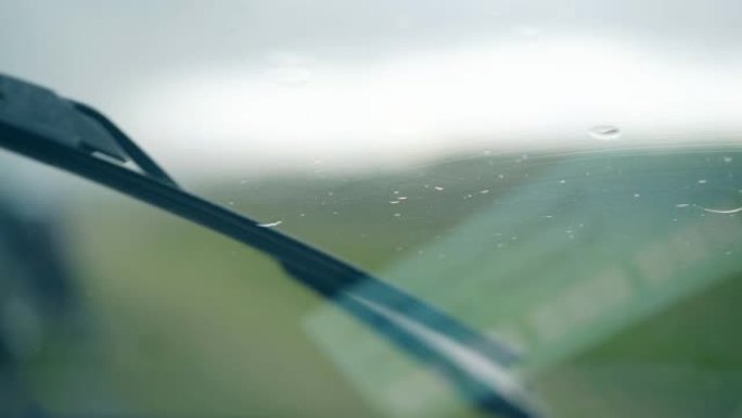 关闭黑色金属雨刮器清洁挡风玻璃上的雨滴