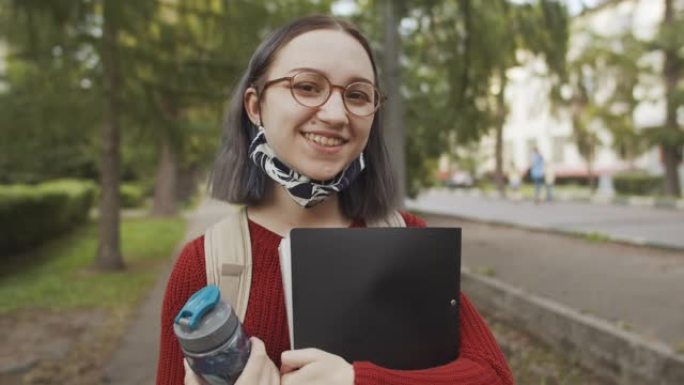 在大学或大学校园附近学校附近的可重复使用的防护口罩中的年轻青少年学生