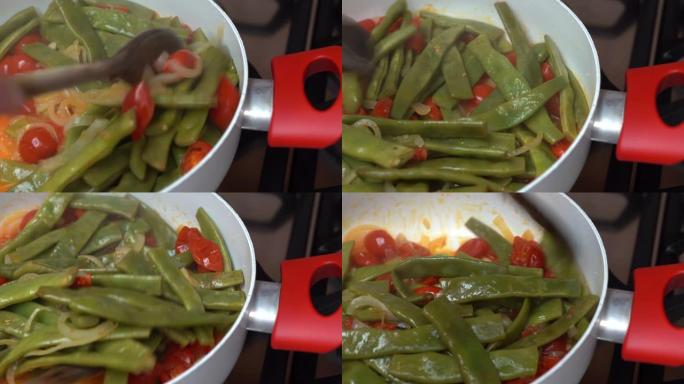 美味的青豆在平底锅上煎炸，配以新鲜的西红柿。女人用木勺翻营养盘。健康素食