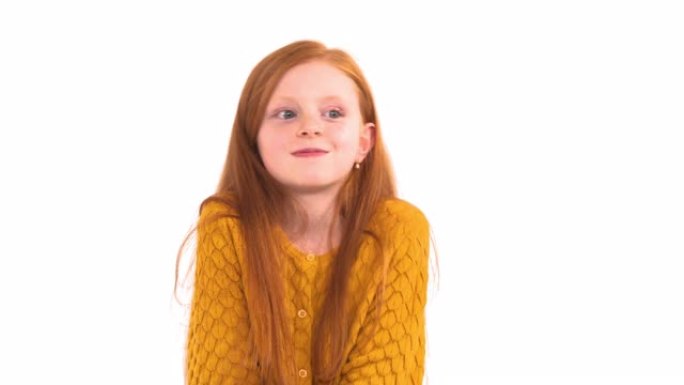 一个可爱的小女孩的肖像，长发，雀斑，脸上表情不愉快，在镜头前摆姿势。孤立，在白色背景上