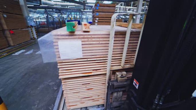 层压板生产工厂。叉车拿走一堆木托盘。拼花板生产仓库的内部。