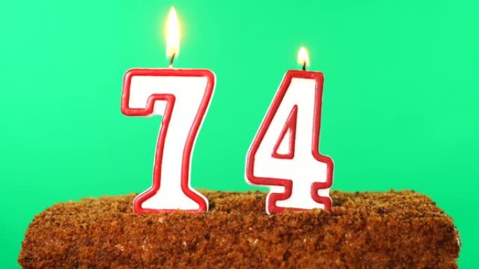 用74号点燃蜡烛的蛋糕。色度键。绿屏。隔离