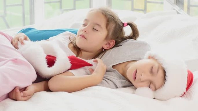 新年晚会结束后，两个精疲力尽的孩子正在睡觉，甜蜜地拥抱着。