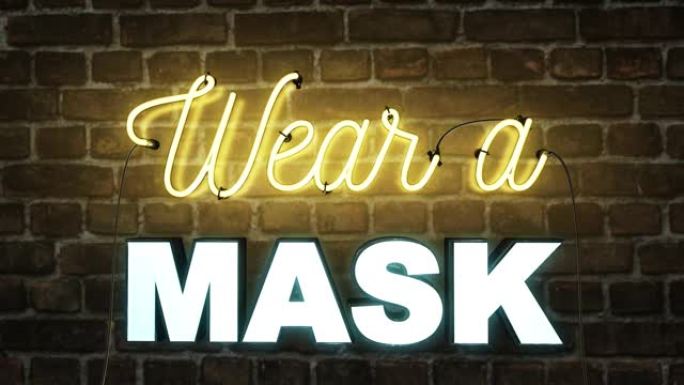 砖墙背景上的霓虹灯标志上写着戴口罩警告人们戴上口罩由于2020冠状病毒新型冠状病毒肺炎大流行，镜头也
