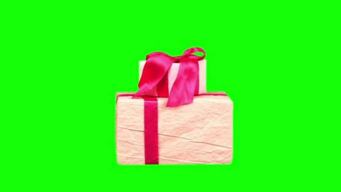 精美包装的礼物，孤立在绿色背景上。特写，旋转。圣诞节或新年。节日包装，礼品盒