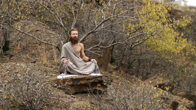瑜伽士在秋天的山上冥想