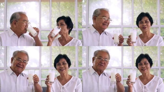 亚洲老年夫妇在家喝牛奶。