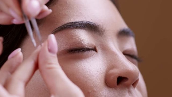美容师在化妆之前先将年轻的亚洲女性的眉毛修剪一下