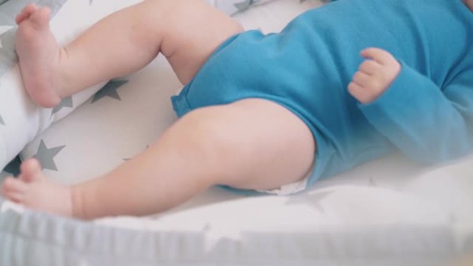 小孩在带雪纺的婴儿床里吮吸假人困扰的腿