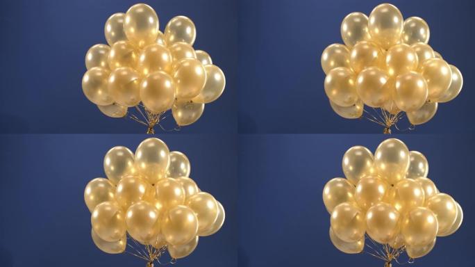 装饰元素-金色气球-在视频中旋转，作为假期的惊喜: 情人节，生日，圣诞节或新年在蓝色背景上。