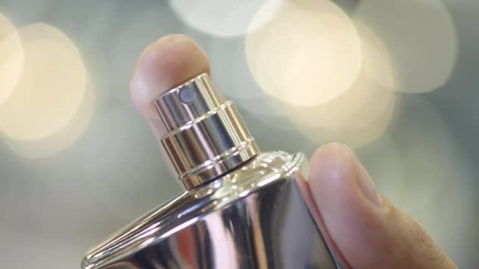 微距独家香水由女性手喷在镜片上