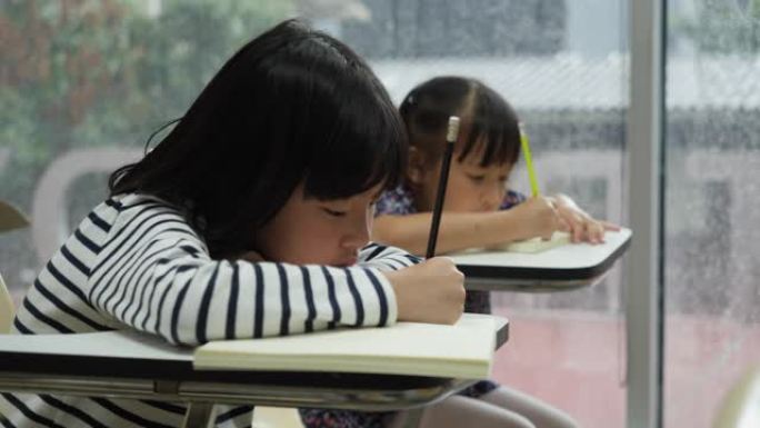 亚洲儿童在学校一起学习和写作教室。教育概念。
