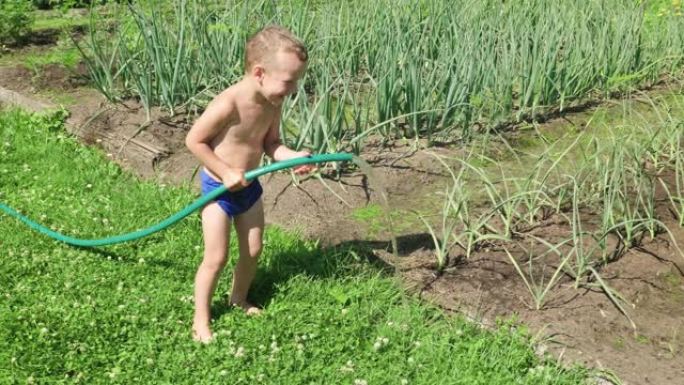 有趣的小男孩玩花园软管