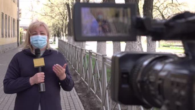 一名戴着防护医用口罩的女记者正在一个荒芜的城市报道。