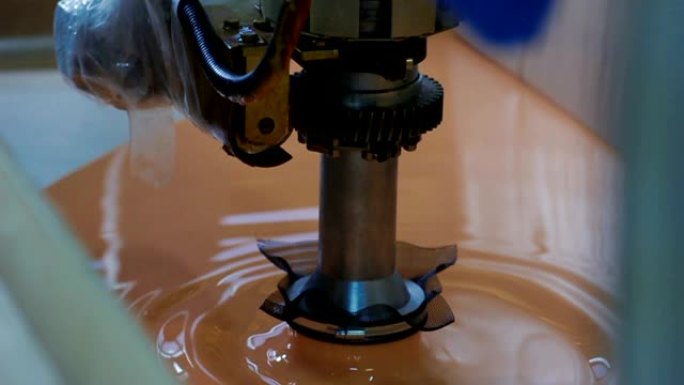 沿着自动机器混合橙色液体橡胶的运动