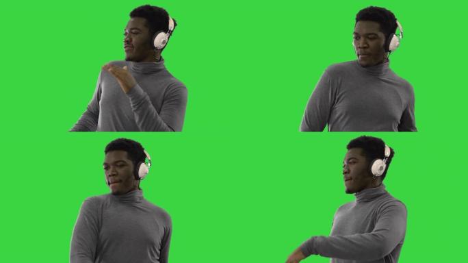热情的非洲裔美国男子戴着耳机听音乐，在绿屏上跳舞，色键