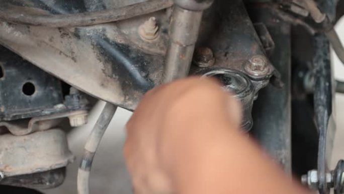 汽车机械师的手用风挡工具松开上臂球形接头的螺栓