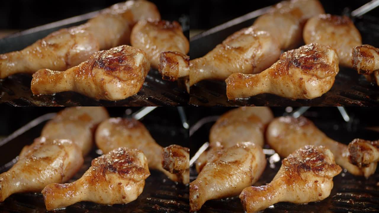 美味的炸鸡鸡腿在煎锅里旋转。
