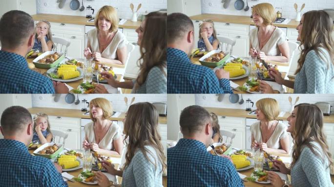 女人在现代厨房里与家人聚餐时聊天