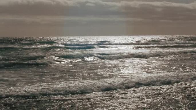 波浪独自在暴风雨的灰色海洋的水面上。暴风雨和恶劣天气的概念