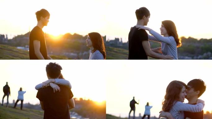 年轻夫妇跳入怀抱并在背景中与太阳接吻