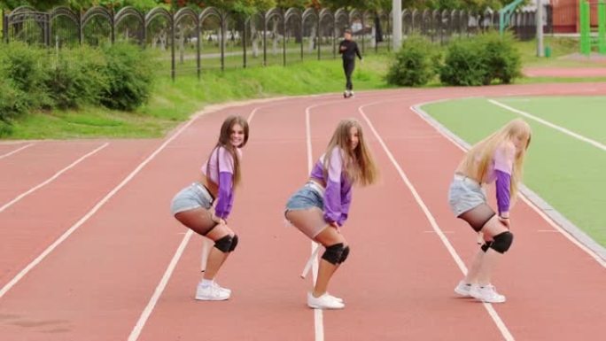 一组三个女孩在夏日在体育场内跳舞现代青年舞蹈自由风格。慢动作