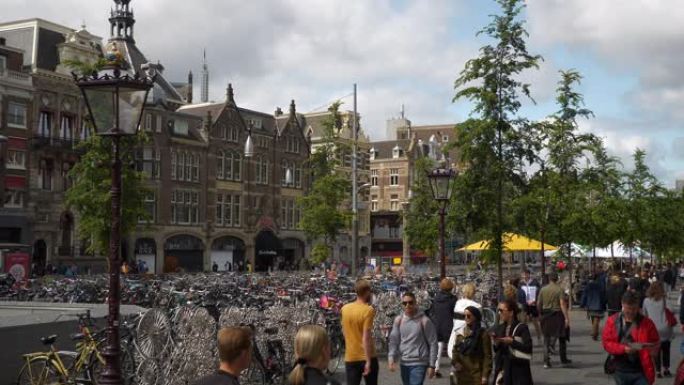 阳光明媚的日子阿姆斯特丹市中心交通街拥挤的人行道自行车停车场慢动作全景4k荷兰