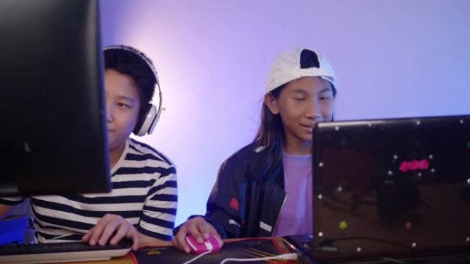 快乐的亚洲孩子晚上在家玩网络游戏和发光二极管灯，生活方式理念。