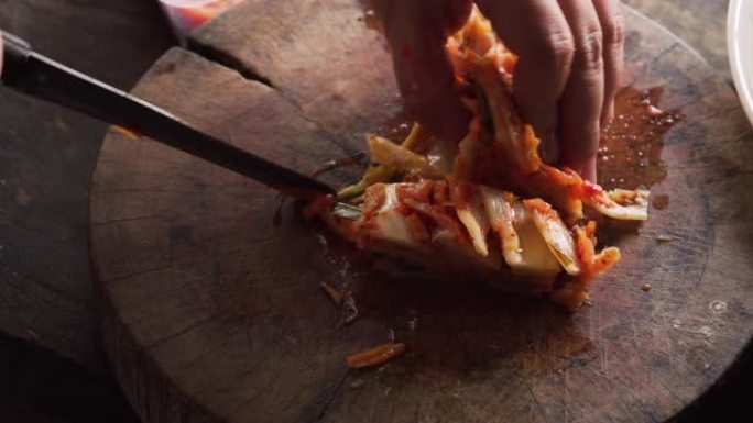 女士用小刀在木板上切泡菜。韩国风味。亚洲食物。自制制剂。特写镜头。