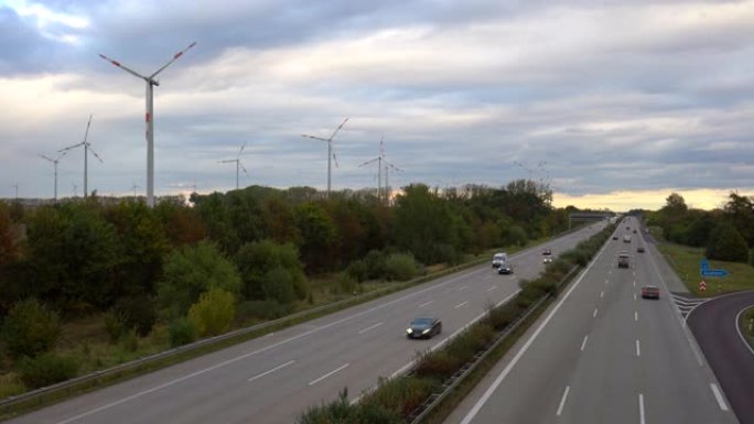 背景为风力涡轮机的德国高速公路上的交通