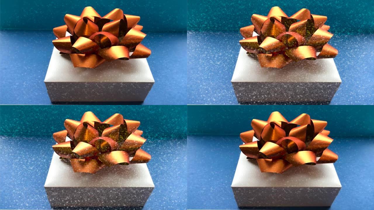 视频有一个带有蝴蝶结的礼品盒和一个模仿雪落在盒子上的视频。