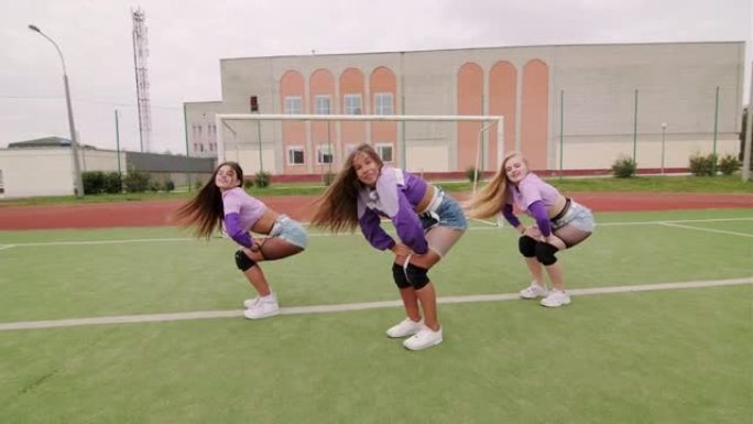 一群年轻开朗的女性在体育场户外跳舞嘻哈舞蹈。