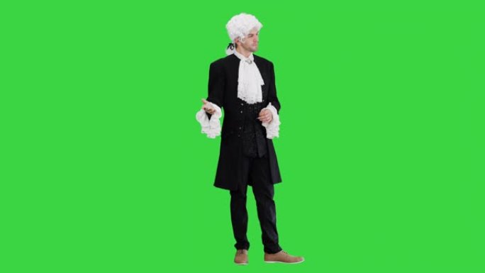 穿着18世纪吊带背心和假发的人在绿色屏幕上做着欢迎的手势，色键