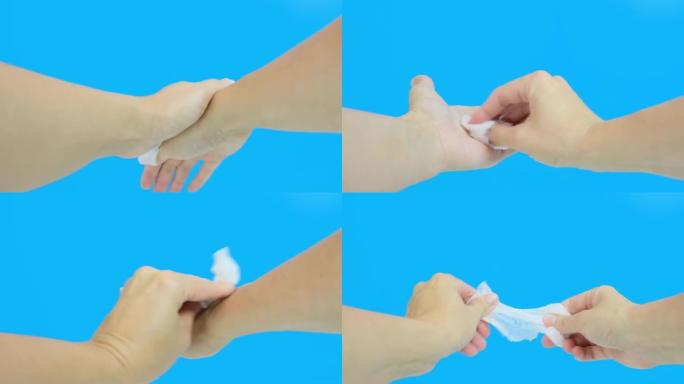 女人手使用湿洗抗菌湿巾，蓝色背景，第一人称视角，卫生和身体护理概念