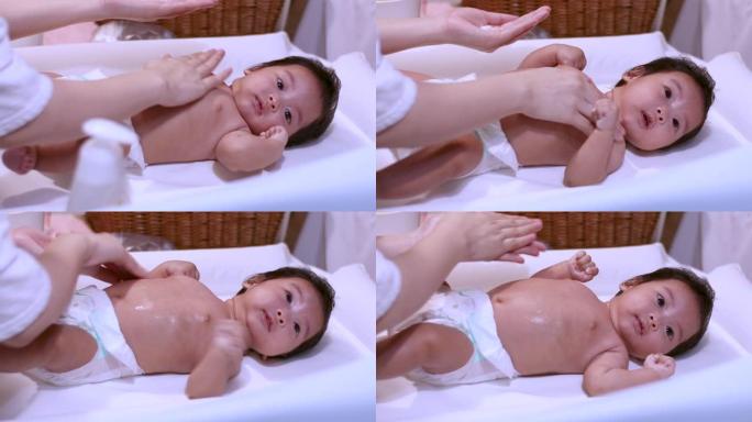 亚洲爸爸在家洗完澡后擦干婴儿女婴的头发，温暖快乐，舒适，毛巾，婴儿躺在桌子上，荧光灯，白天