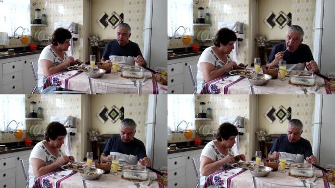 60多岁的已婚老年夫妇在家庭厨房用餐