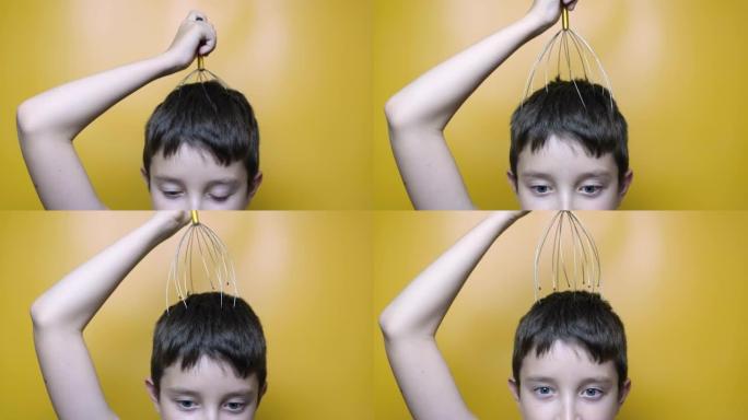一个高加索男孩享受头部头皮按摩通过抗压力针灸金属章鱼工具，设备，她愉快地闭上眼睛，黄色背景，特写镜头