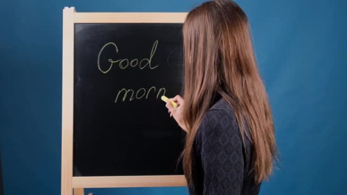 女性在黑板上写下题词早上好。美好的一天概念