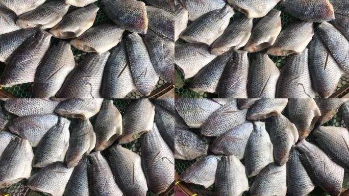 丝足鱼是用阳光晒干鱼的植物。腌渍保存海鲜生鱼片在当地市场的柳条桌上晒干。