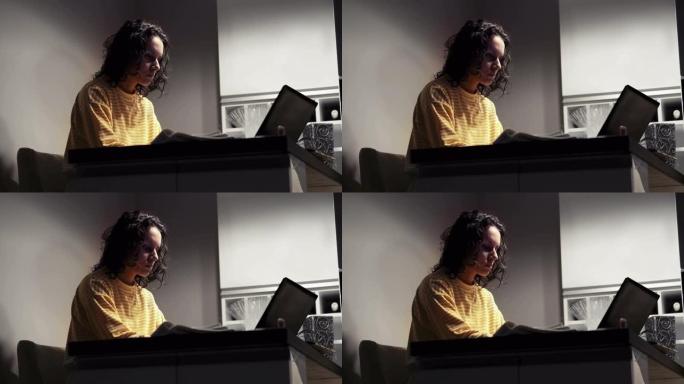 年轻女记者晚上独自在办公室工作时在笔记本电脑上写文章