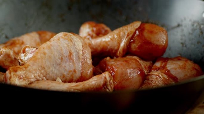 用香料在煎锅里的生鸡腿旋转。