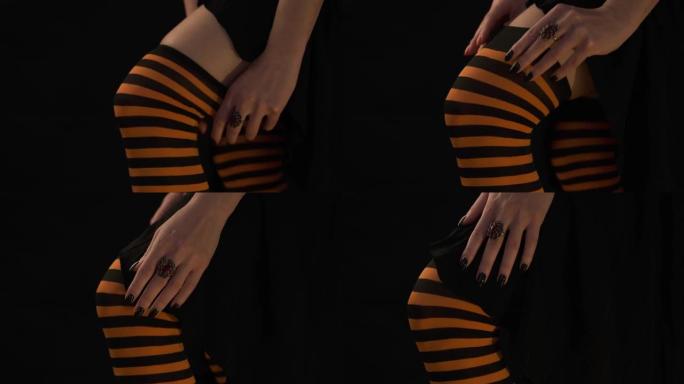 女人穿上黑色和橙色条纹长统袜。