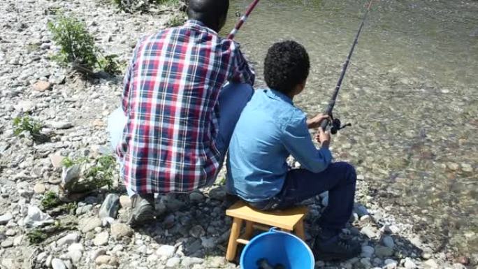 小男孩和他父亲钓鱼的背影