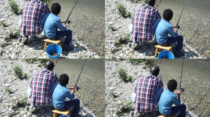 小男孩和他父亲钓鱼的背影