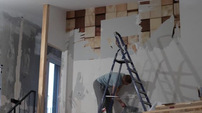 人在用刮刀清除旧墙纸的过程中。准备贴新壁纸的墙。延时