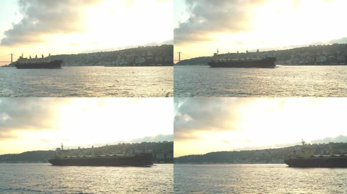 看着博斯普鲁斯海峡美丽的城市景观和风景，看到货船在土耳其伊斯坦布尔经过，同时乘船游览，在夏天的日落下