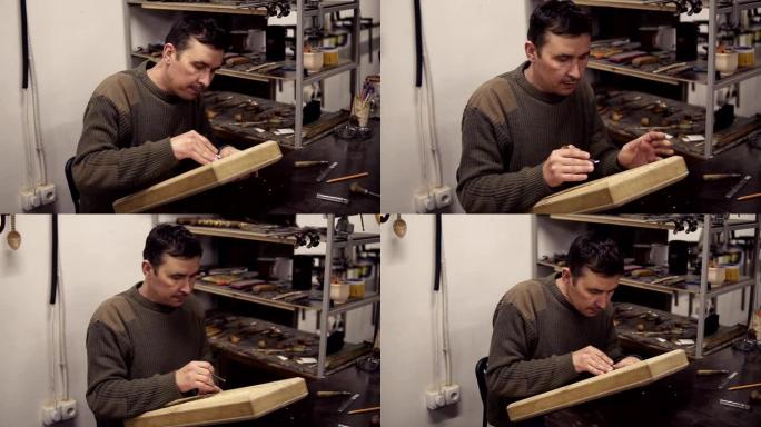 高加索木匠用弯曲的凿子在木制工件上做缺口。一位工匠坐在他的工作场所，在双陆棋上雕刻木制装饰品。慢动作