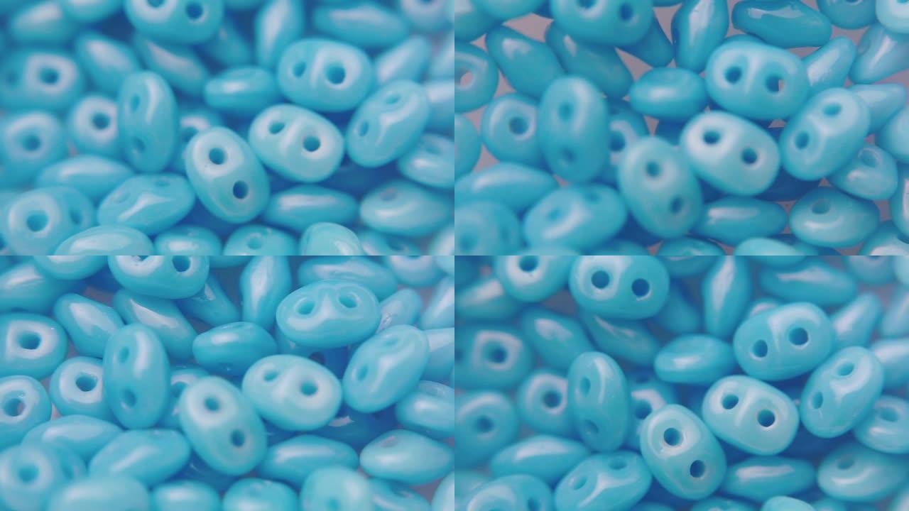 一个有两个孔的蓝色珠子的特写镜头。