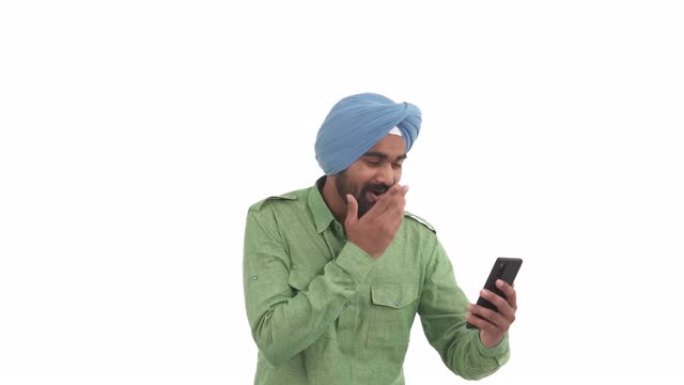 印度年轻人手持智能手机的肖像，看着电话屏幕，表示惊喜。拳头打气手势。孤立在白色背景上
